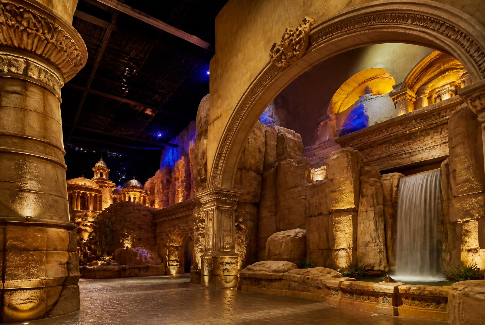 Themed entertainment interior with sculpted rockwork, arches and dramatic lighting