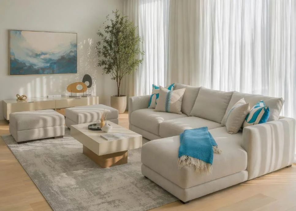 Neutral living room with two sofas, armchair, tables and full-height curtains