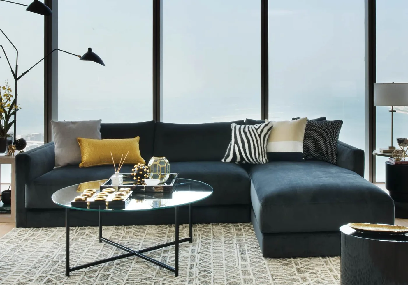 Dark sectional sofa and glass table in a high-rise living room