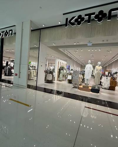 Koton store frontage with stone-effect fascia, polished floor and open shop-floor merchandising