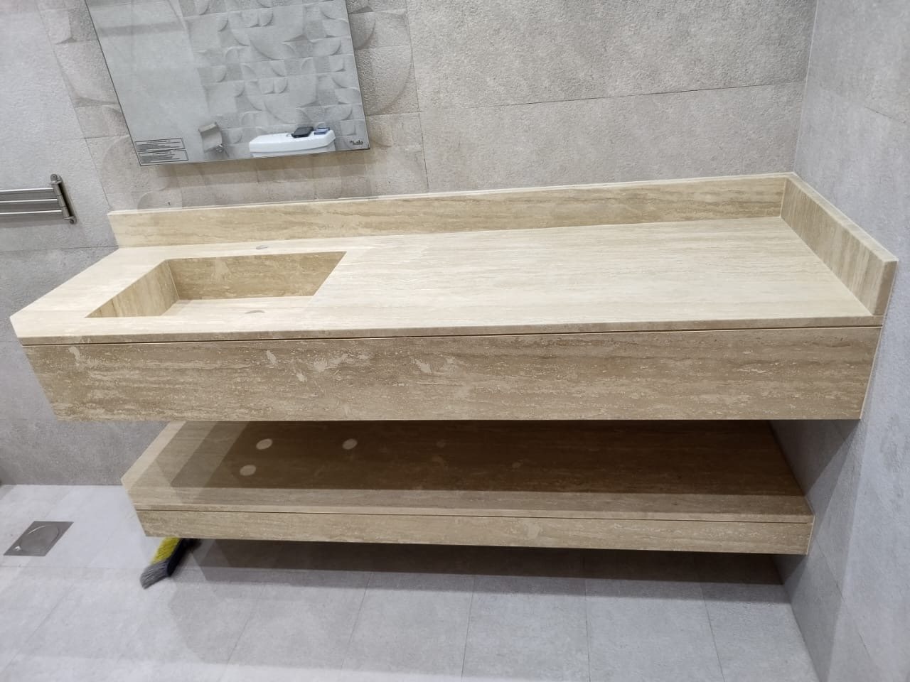 Cream banded stone vanity with integrated basin and open shelf