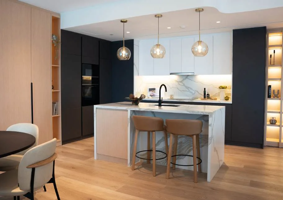Apartment kitchen with island stools, pendant lights and timber storage