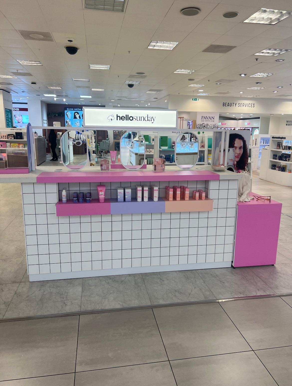 Hello Sunday beauty concession with tiled counter, pink laminate surfaces, oval mirrors and lightbox sign