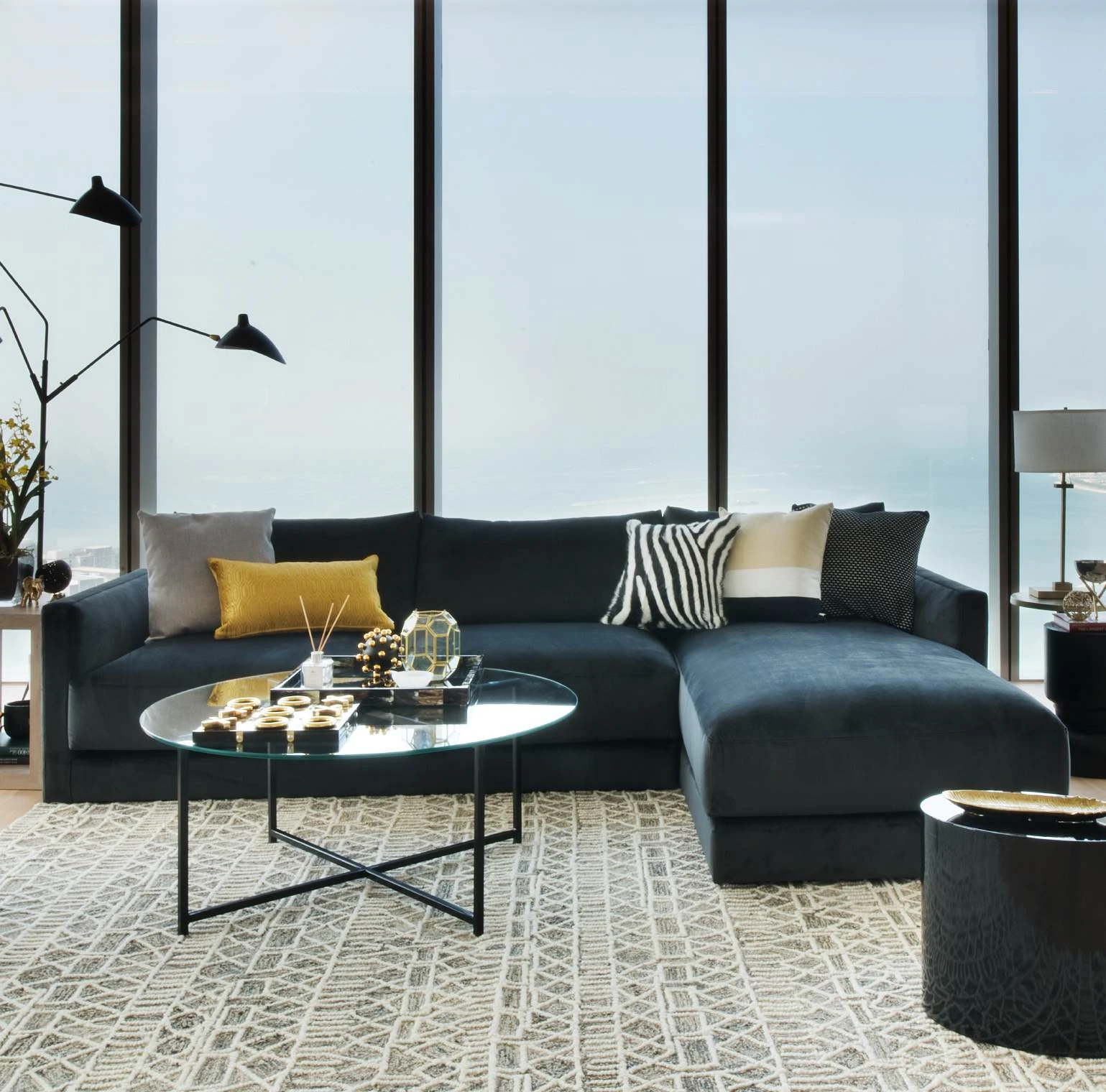 Sectional sofa with occasional tables beside full-height windows