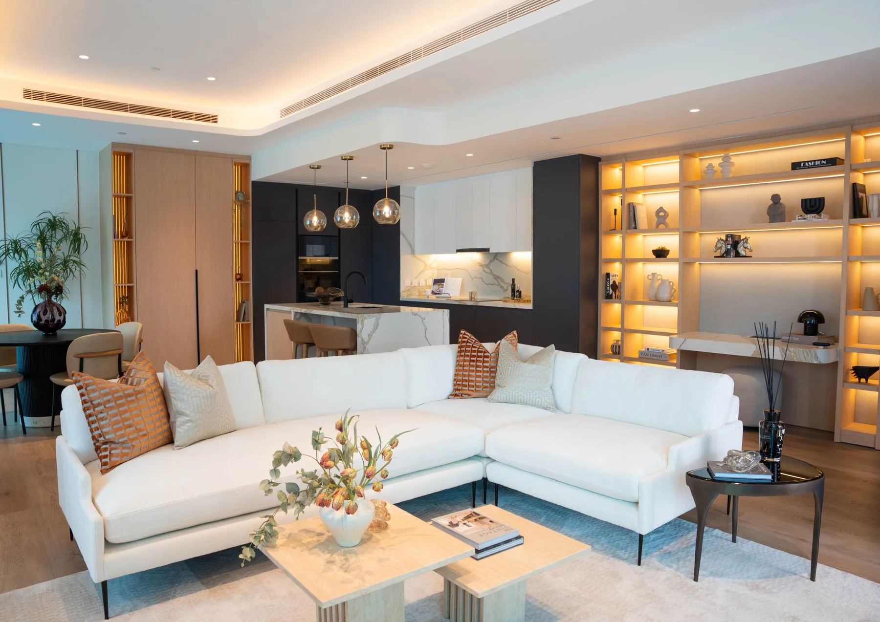 Contemporary apartment living room with sectional sofa and illuminated shelving