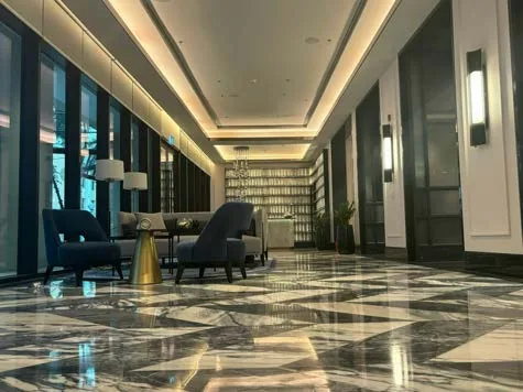 Corridor with polished patterned stone flooring and panelled walls