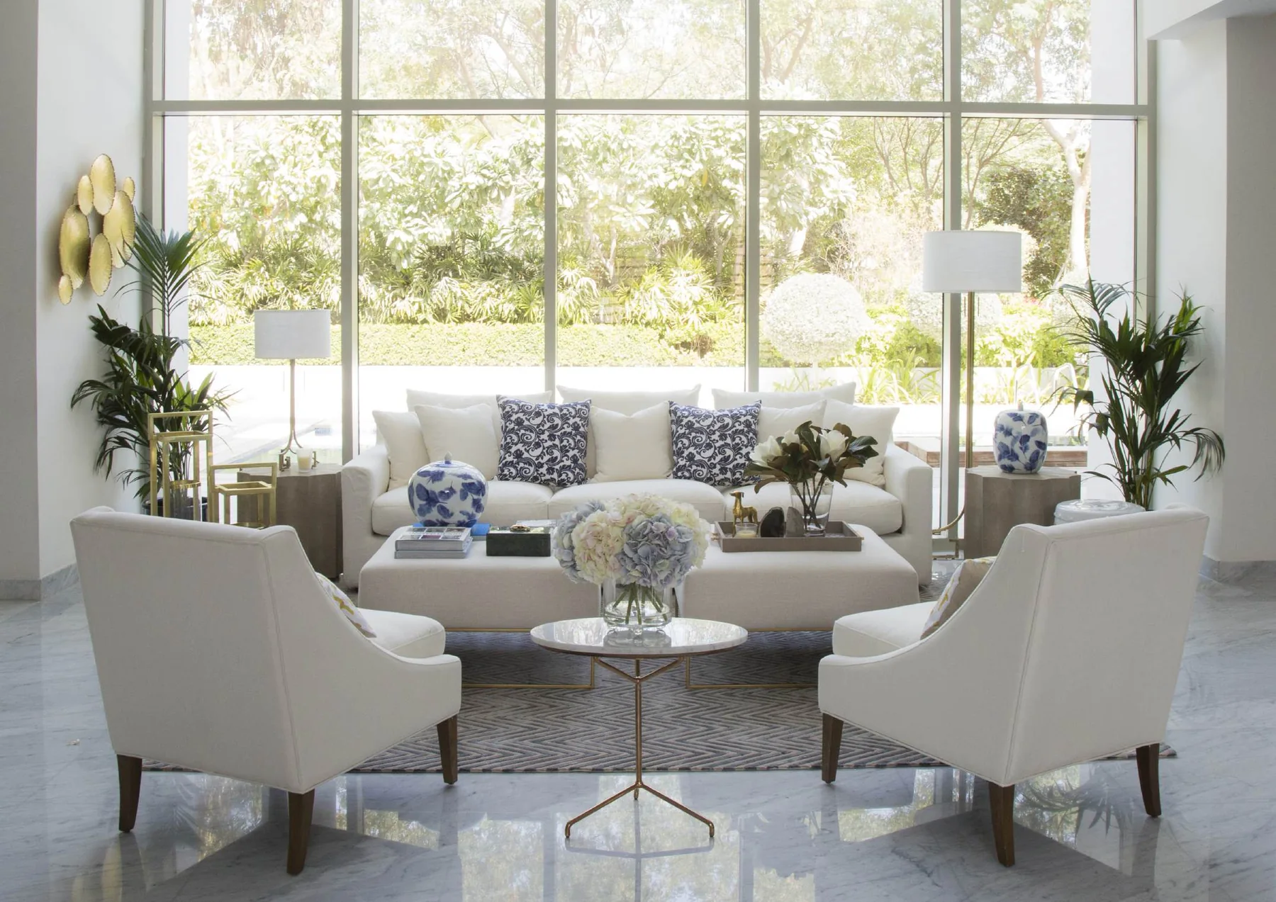 Bright living room with pale seating, rust armchairs and garden windows