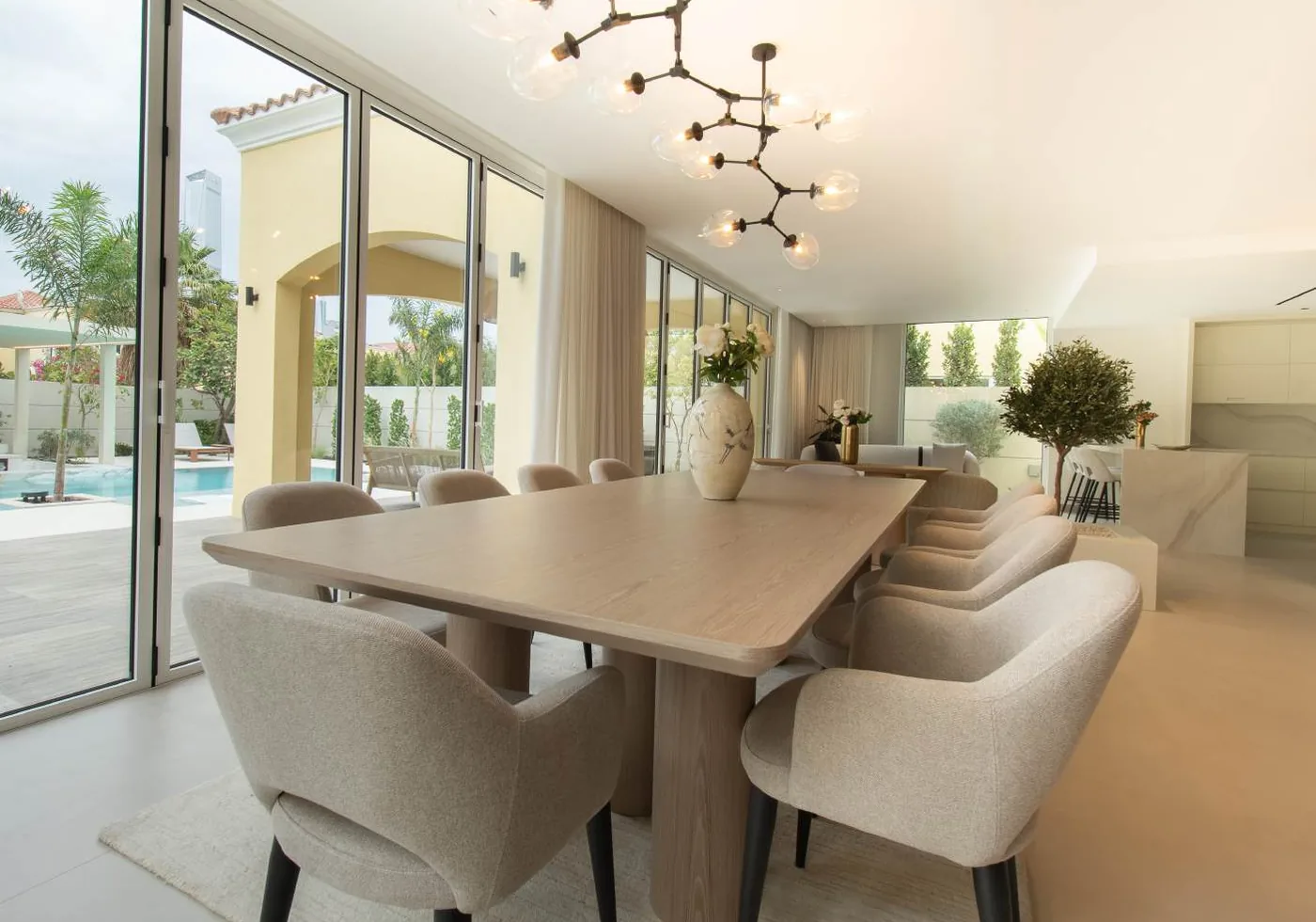 Dining room with timber table, upholstered chairs and garden-facing glazing