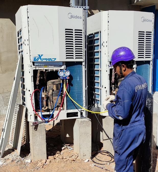 Technician commissioning an installed air conditioning unit