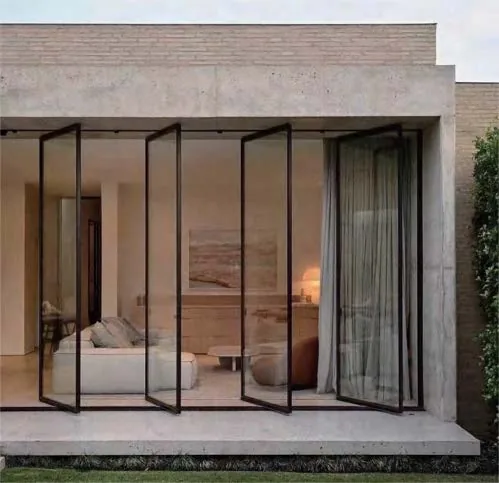 Full-height glazed doors between a bedroom and a planted terrace