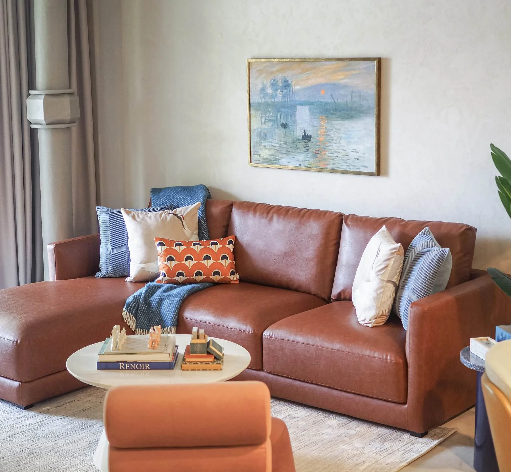 Warm leather sofa with cushions, ottoman and coffee table