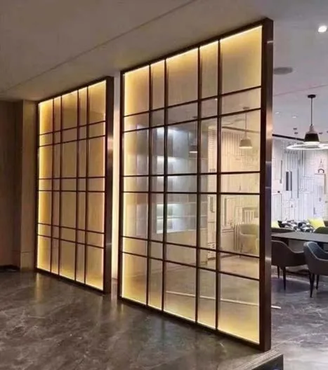 Backlit metal-framed screen dividing a hotel public area