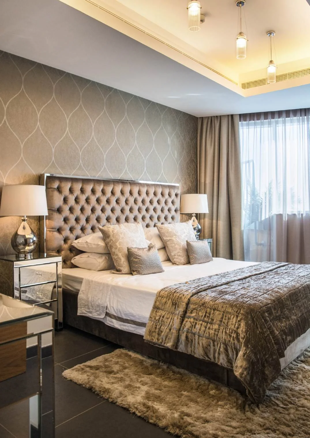 Guest bedroom with upholstered bed, bedside tables and patterned wall finish