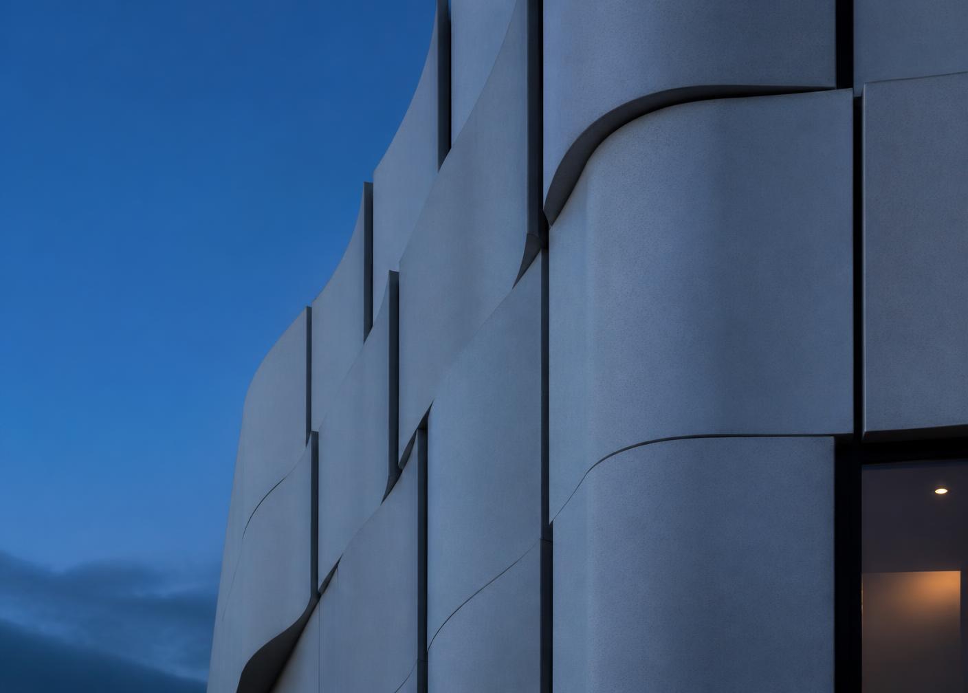 Curved glassfibre reinforced concrete facade panels at blue hour