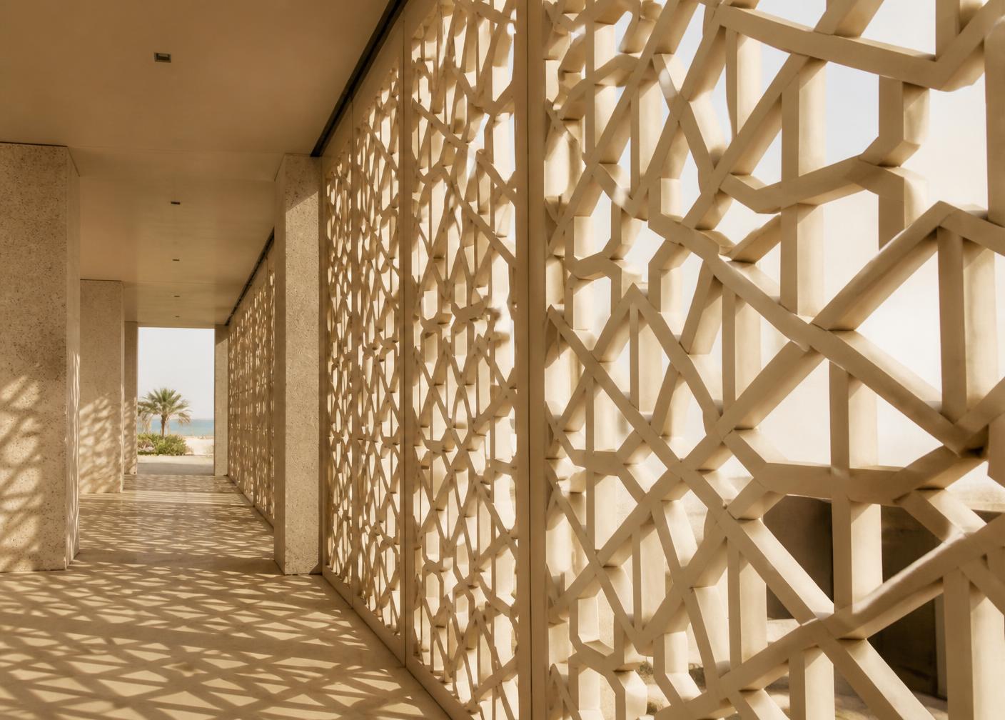 Perforated geometric screen wall casting patterned shadows