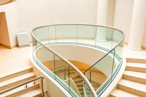 Frameless glass balustrade to a curved stair with stainless handrail