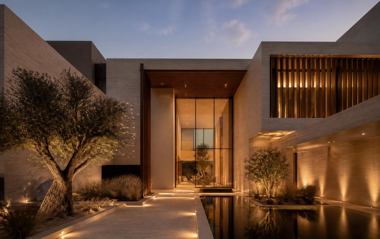 Contemporary Dubai villa at dusk with travertine walls, timber screens and a reflection pool at the arrival court