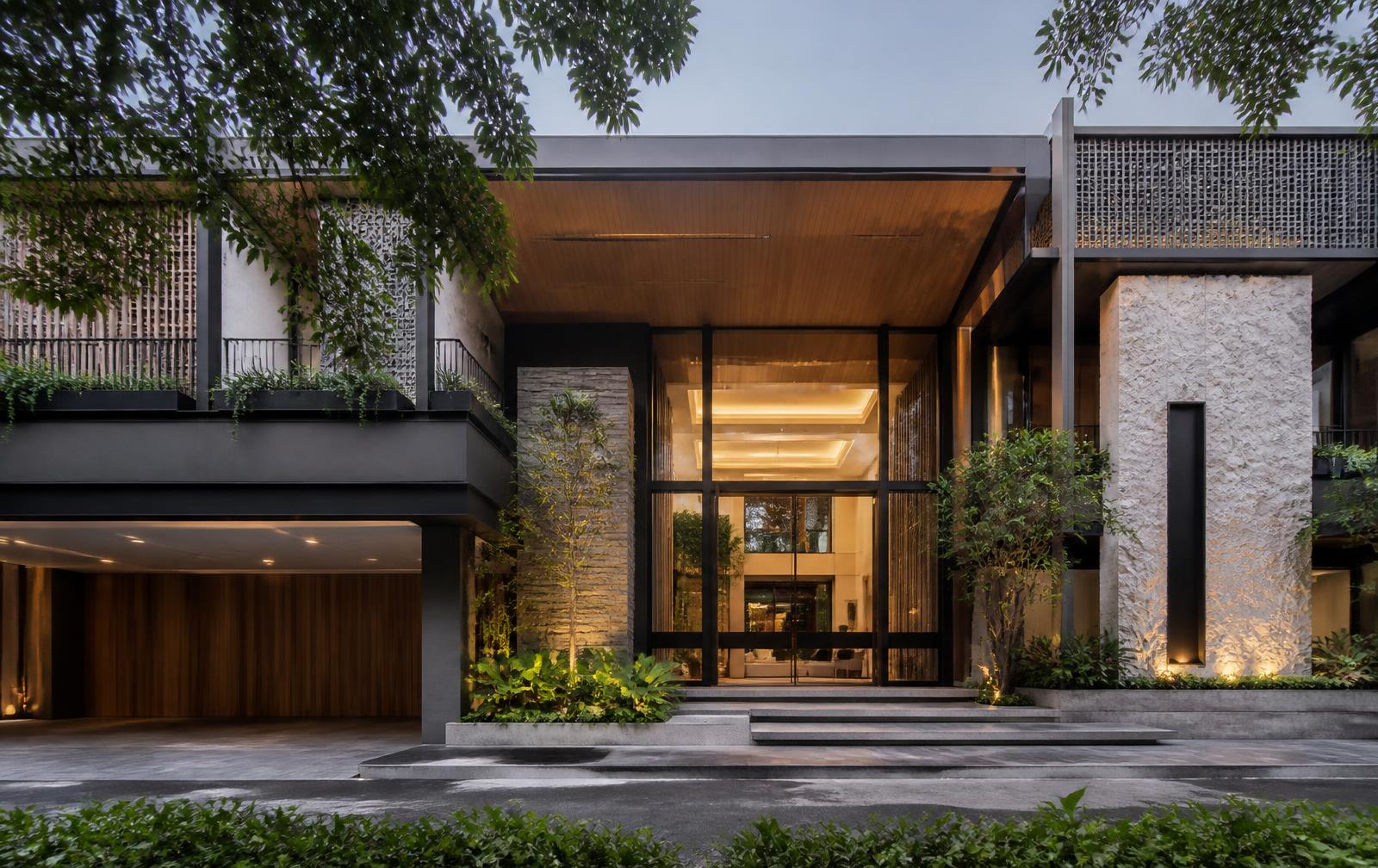 Contemporary Mumbai private residence with stone screens, timber soffits and a lit entrance portico